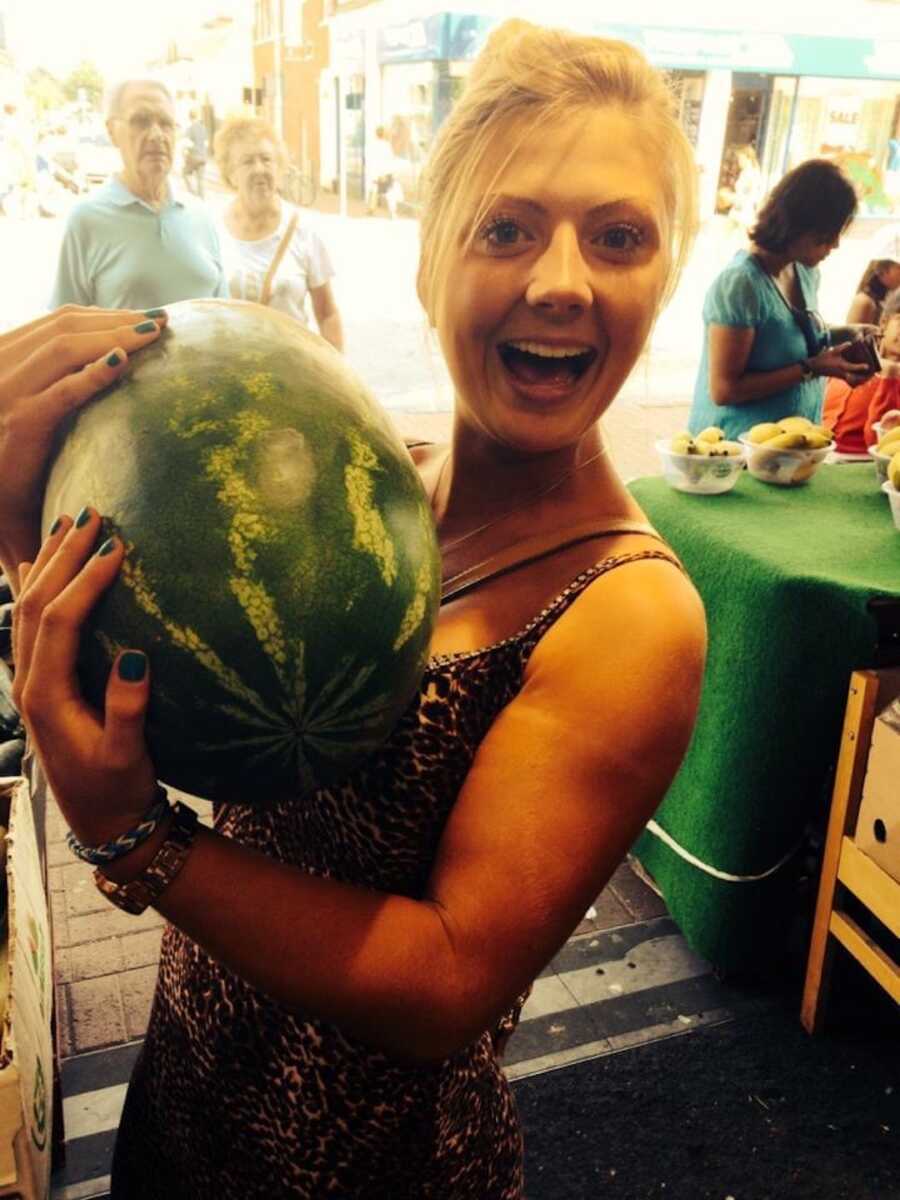 woman holding a watermelon in her arms