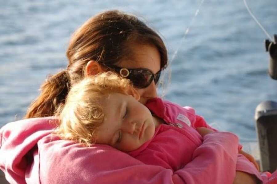 young girl sleeping on her mother