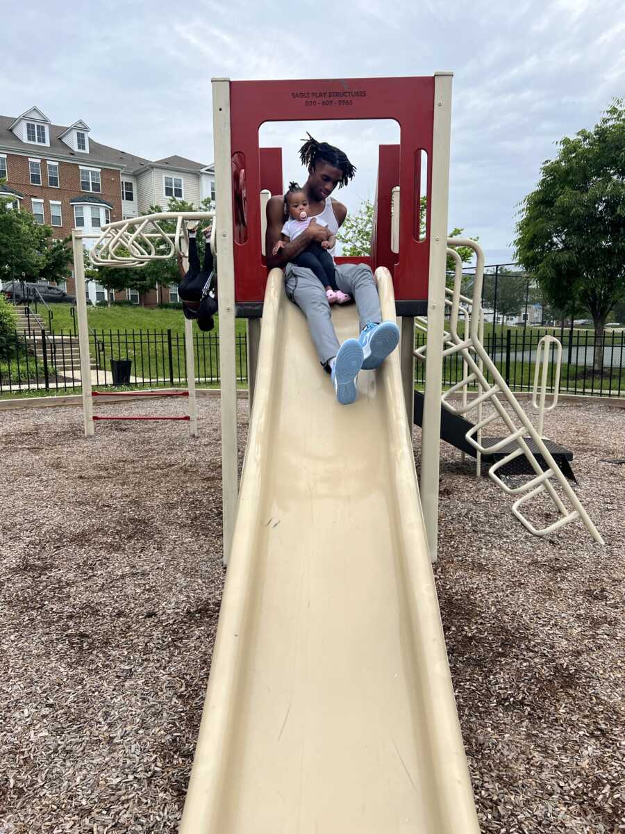 dad taking his daughter down the slide