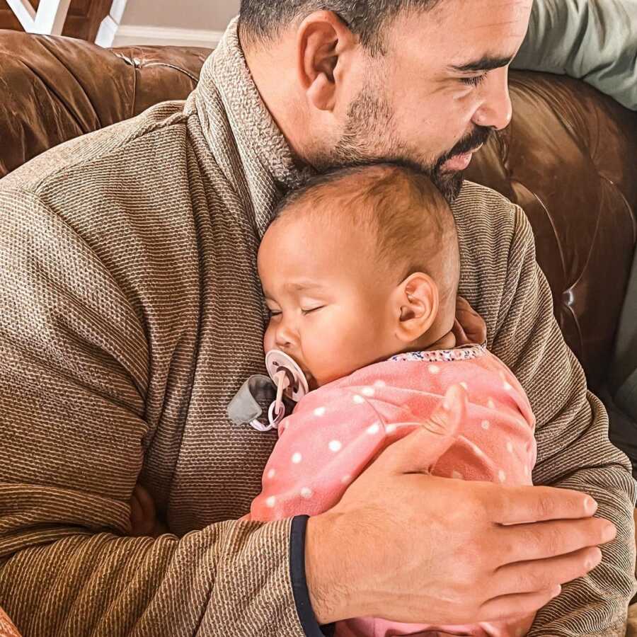 dad holds adopted baby girl on his chest