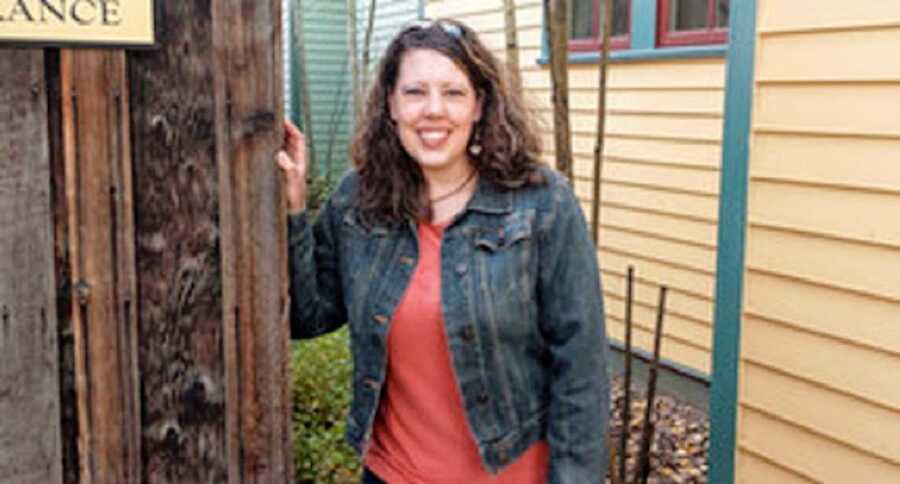 A woman wearing a jean jacket and a red shirt