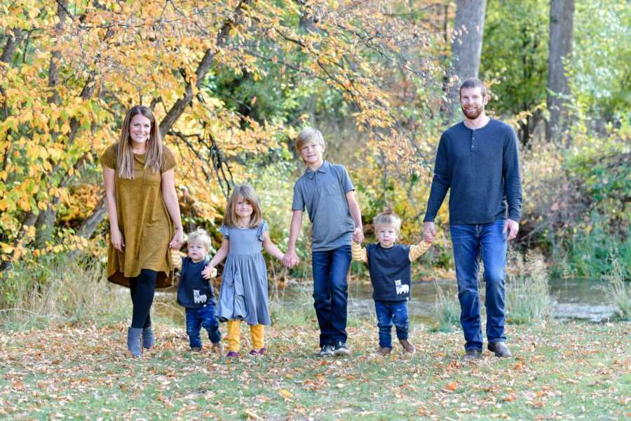 Couple takes family picture with four children they miraculously conceived despite infertility struggles. 