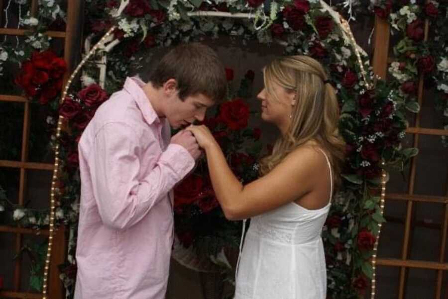 Young man kisses new brides hand as they elope and getting married in Las Vegas.