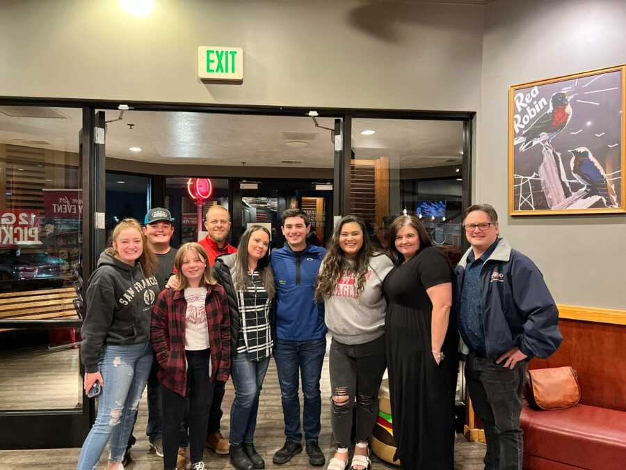 Adoptee takes group picture with adoptive and biological family, first meeting his birth family as an adult.