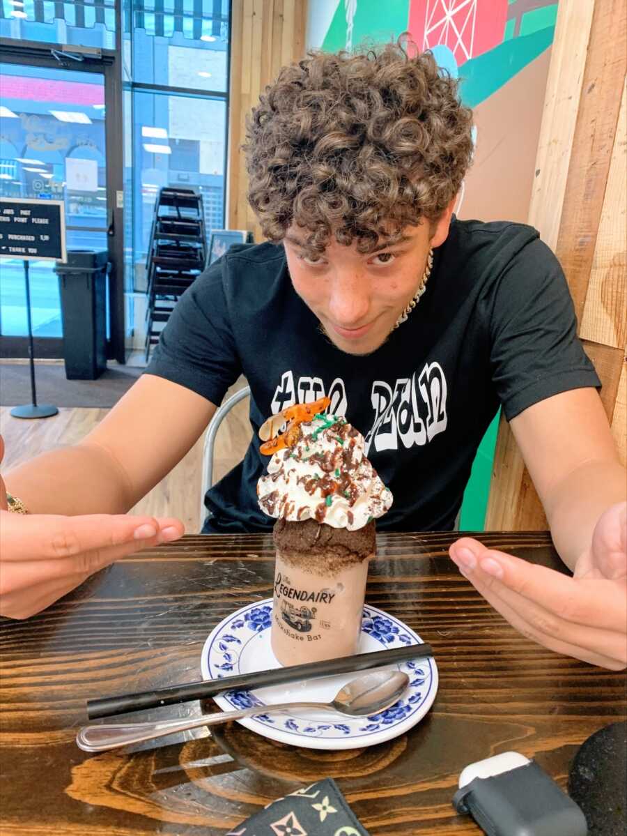 A boy points at an ice cream sundae