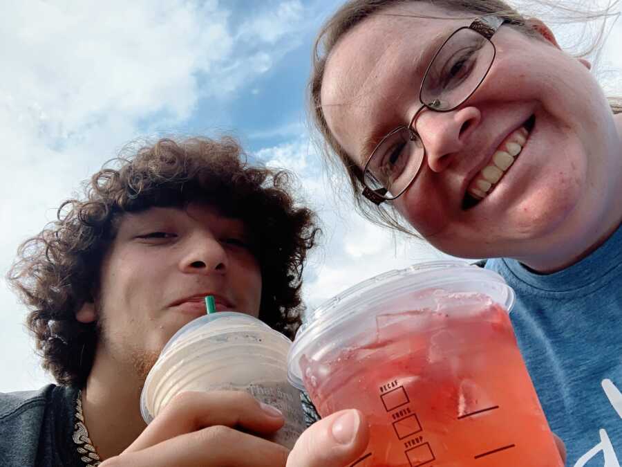 A teenage boy and his mom drinking out of plastic cups