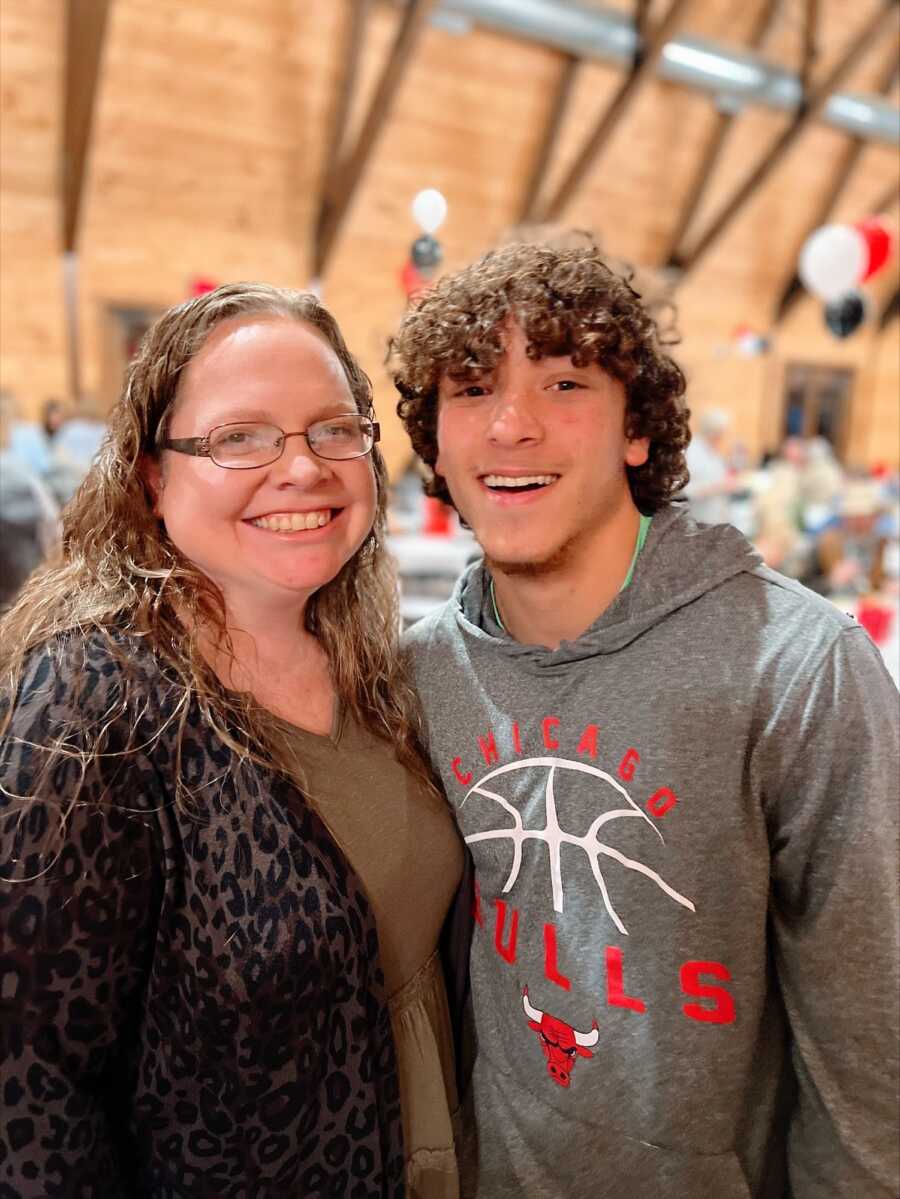 A foster mom and her teenage son wearing a grey sweatshirt