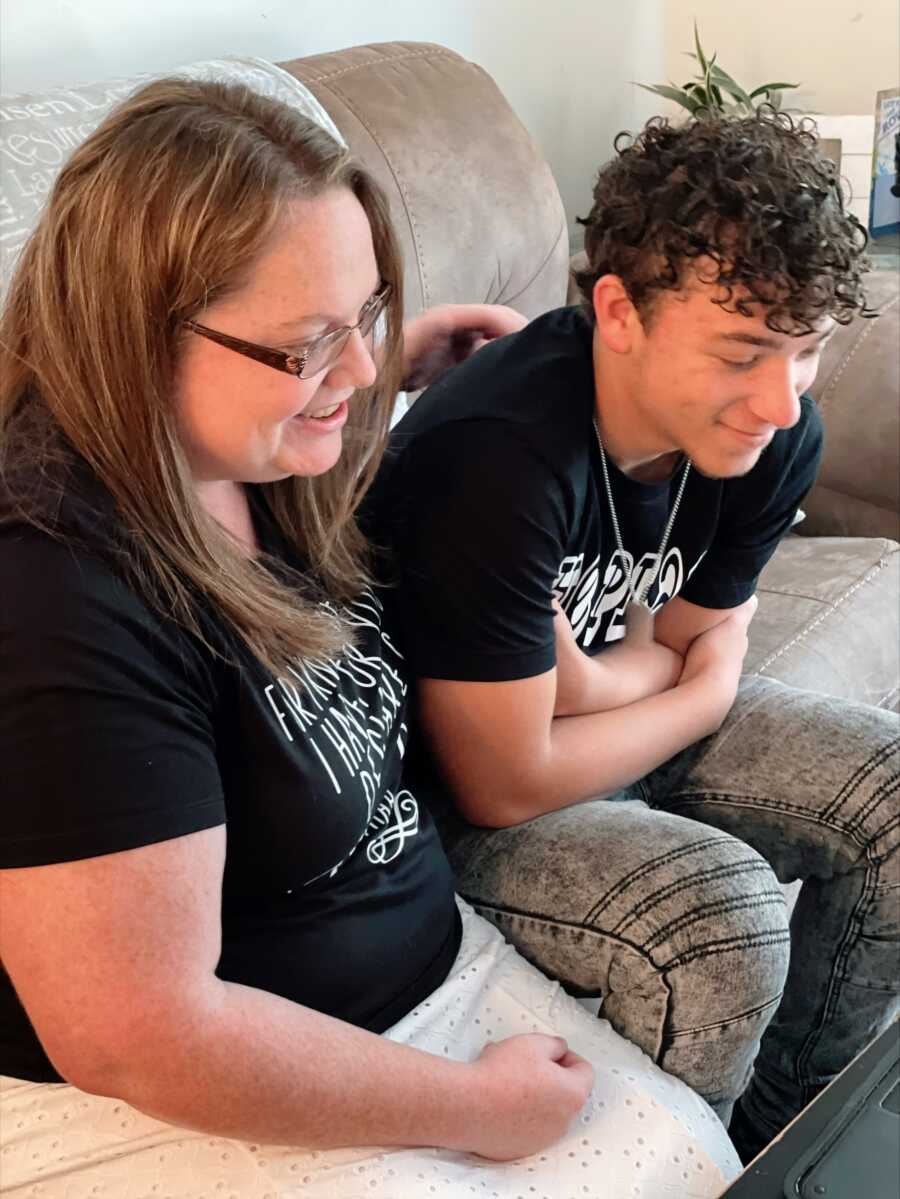 A woman and her son looking at a laptop