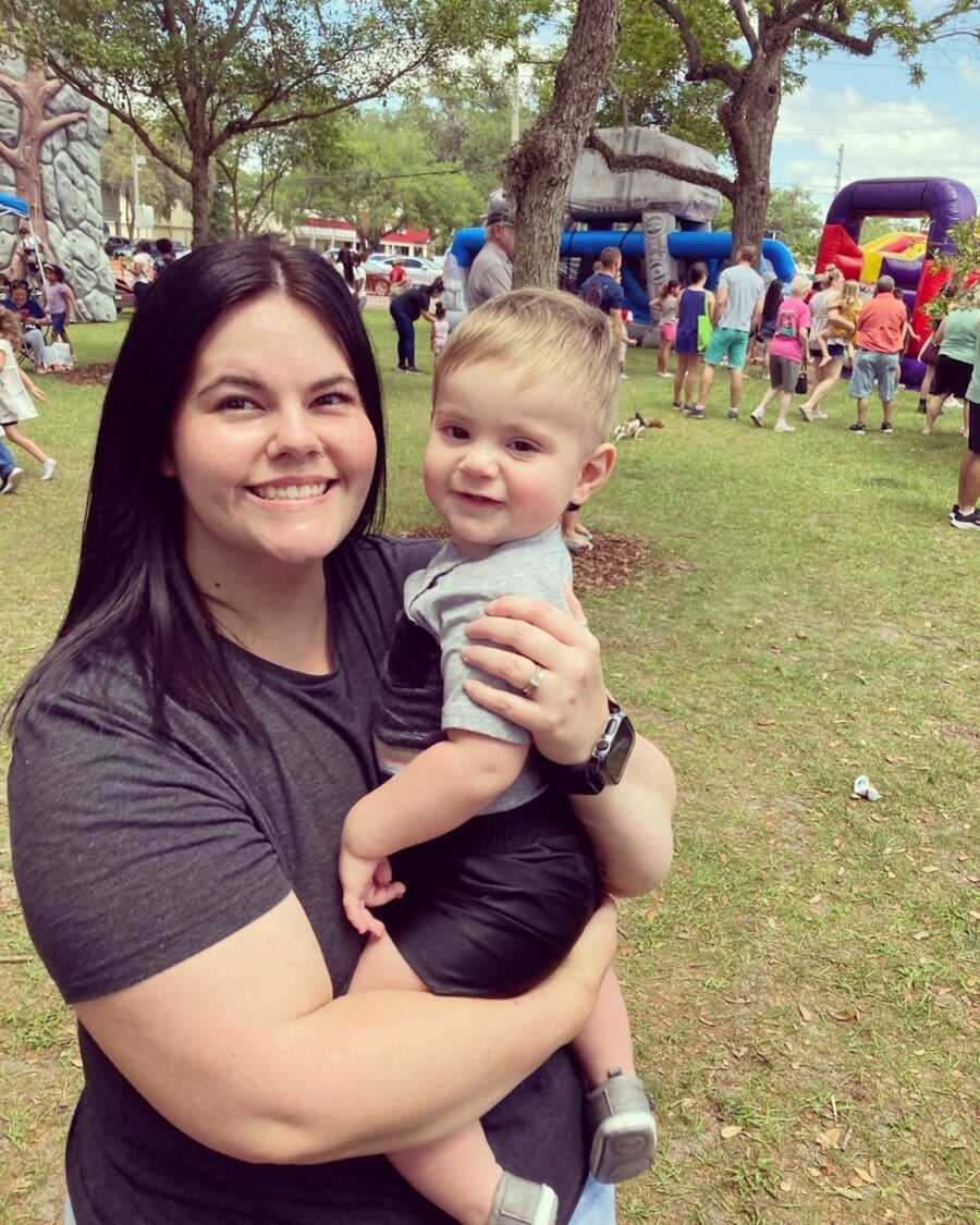 mom embraces her son, both are smiling