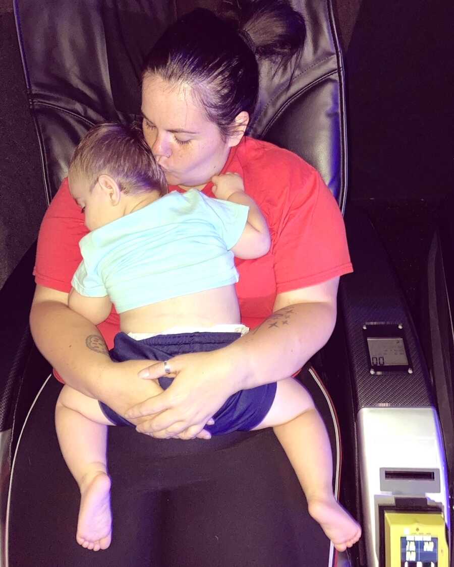 mom holds her youngest son in her lap while he sleeps