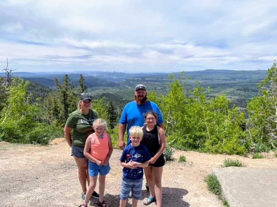 A family poses together at the top of the mountain