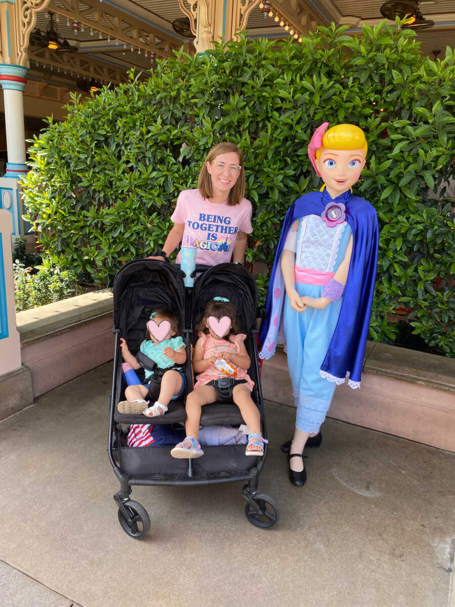 Single foster mom takes picture with baby sisters in stroller at Disneyland.