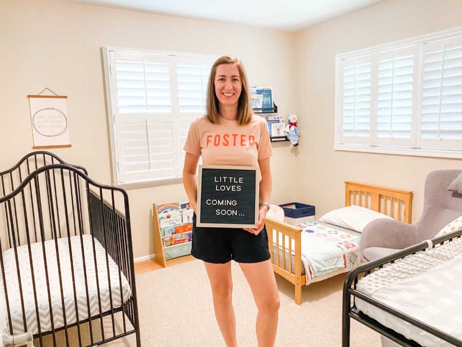 Young widow holds up letter board announcing becoming a licensed foster mom.