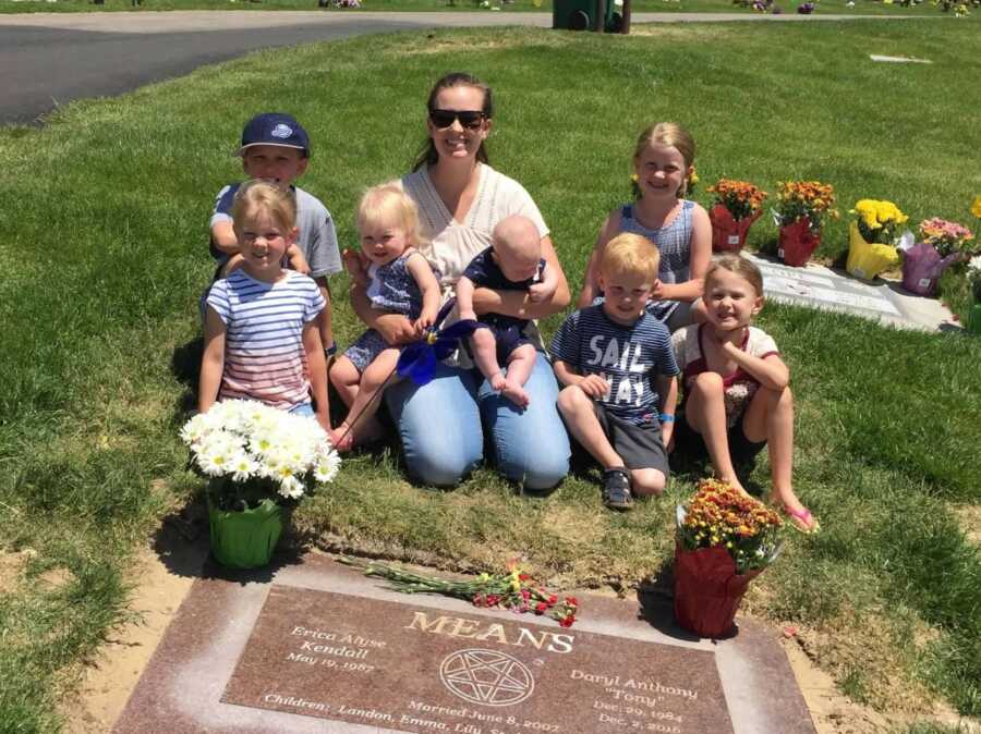 Young widow sits at husband's grave with her seven small children.