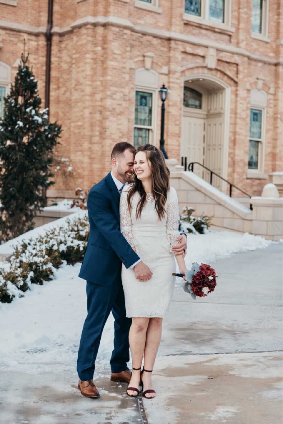 Widow and widower just remarried take winter wedding picture standing outside together.