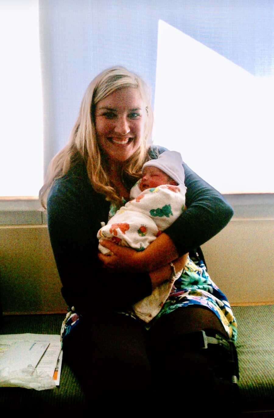 woman sitting with newborn in her arms 