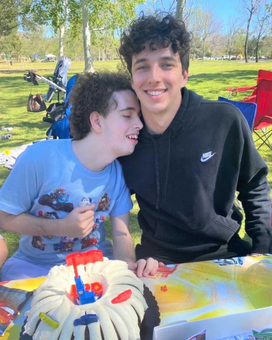 Younger brother takes picture with brother with rare genetic disease at his birthday party.