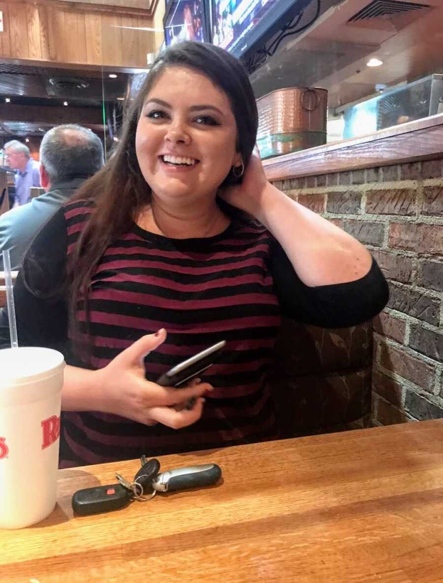 woman sits at booth in restaurant