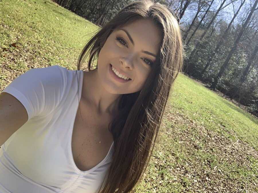 woman takes a selfie outside while smiling