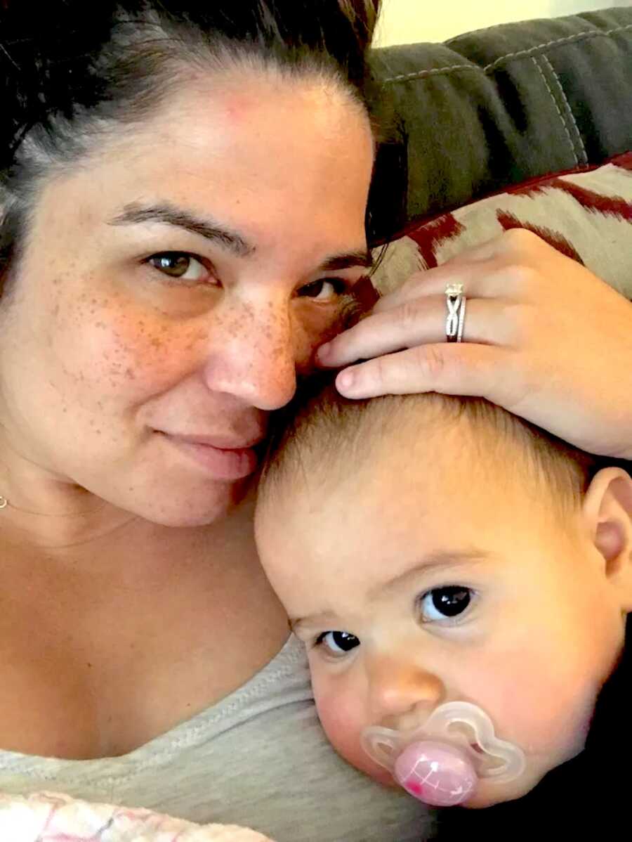 mom takes a selfie with her baby daughter, resting heads together