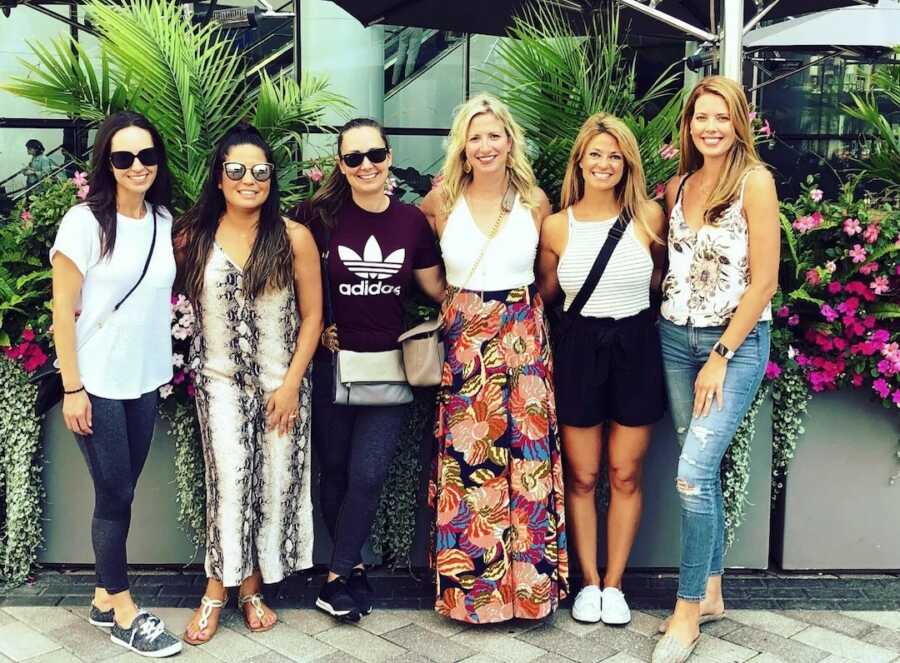 group of women on a girls trip standing together smiling