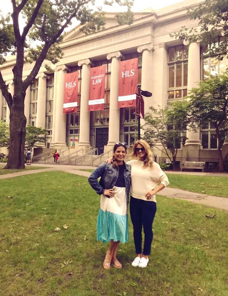 mom stands with her friend smiling while on a girls trip