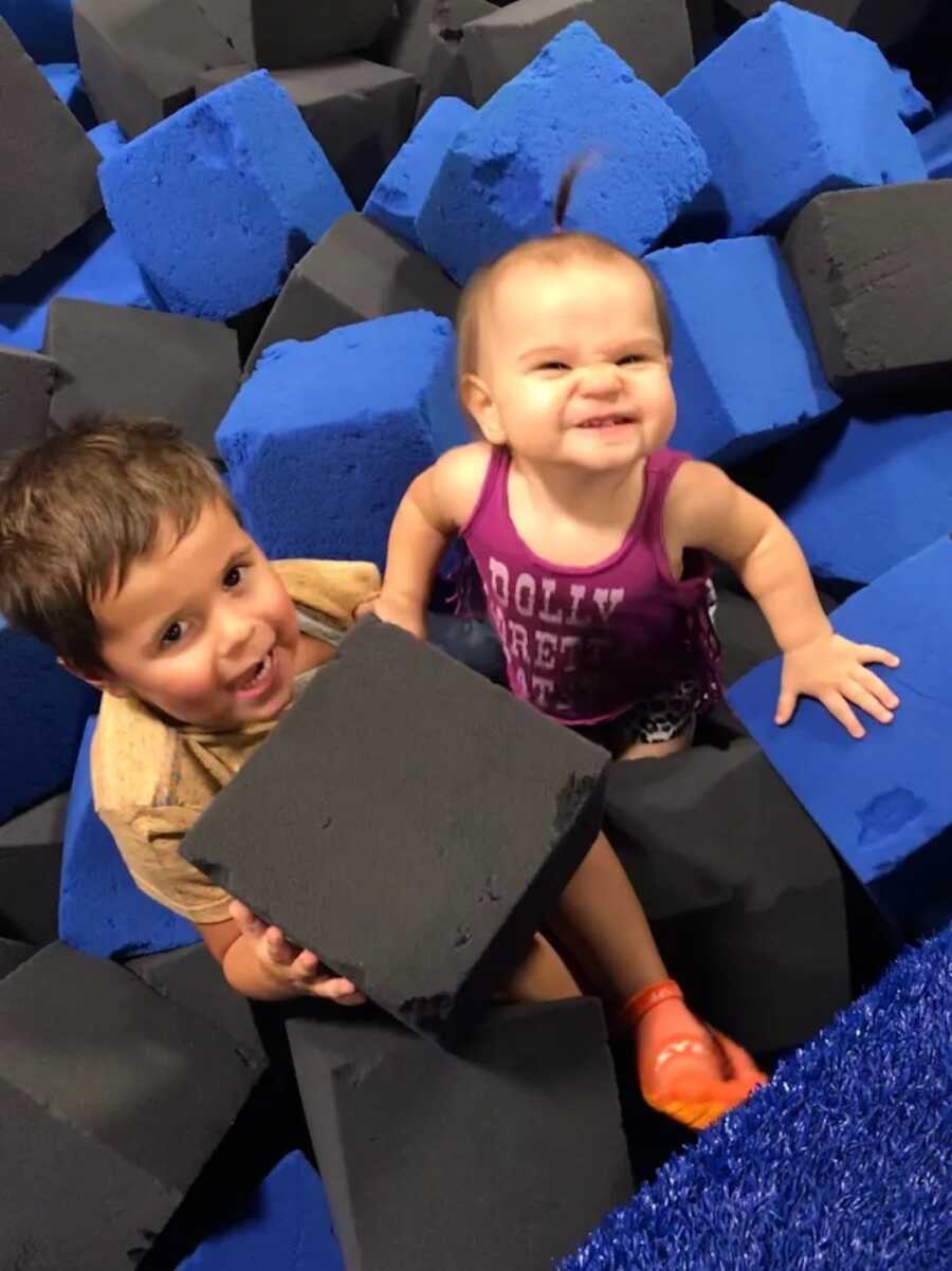 siblings, brother and sister, play in a foam pit