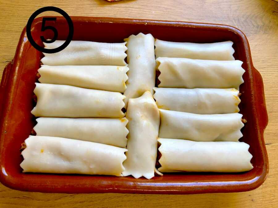 canelones rolled up and lined up in baking dish