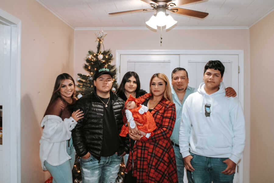 A family poses in front of a Christmas tree