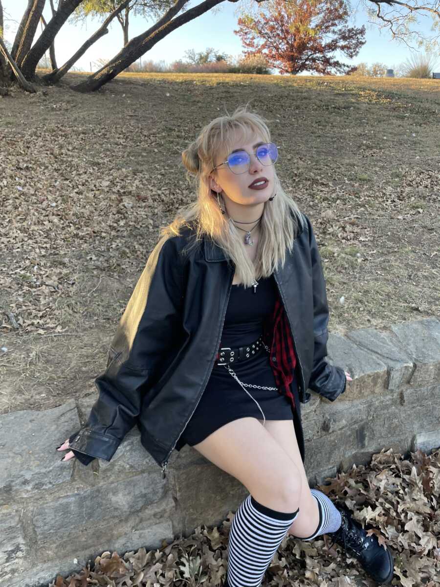 A teenage advocate in a leather jacket and black outfit looks into the camera 