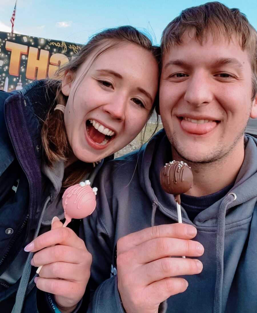 A woman and man together holding cake pops