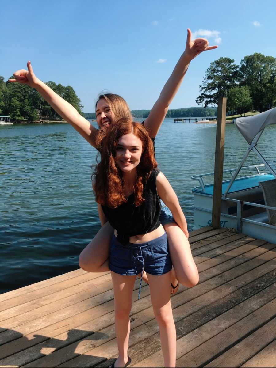 A young woman with her friend by the water