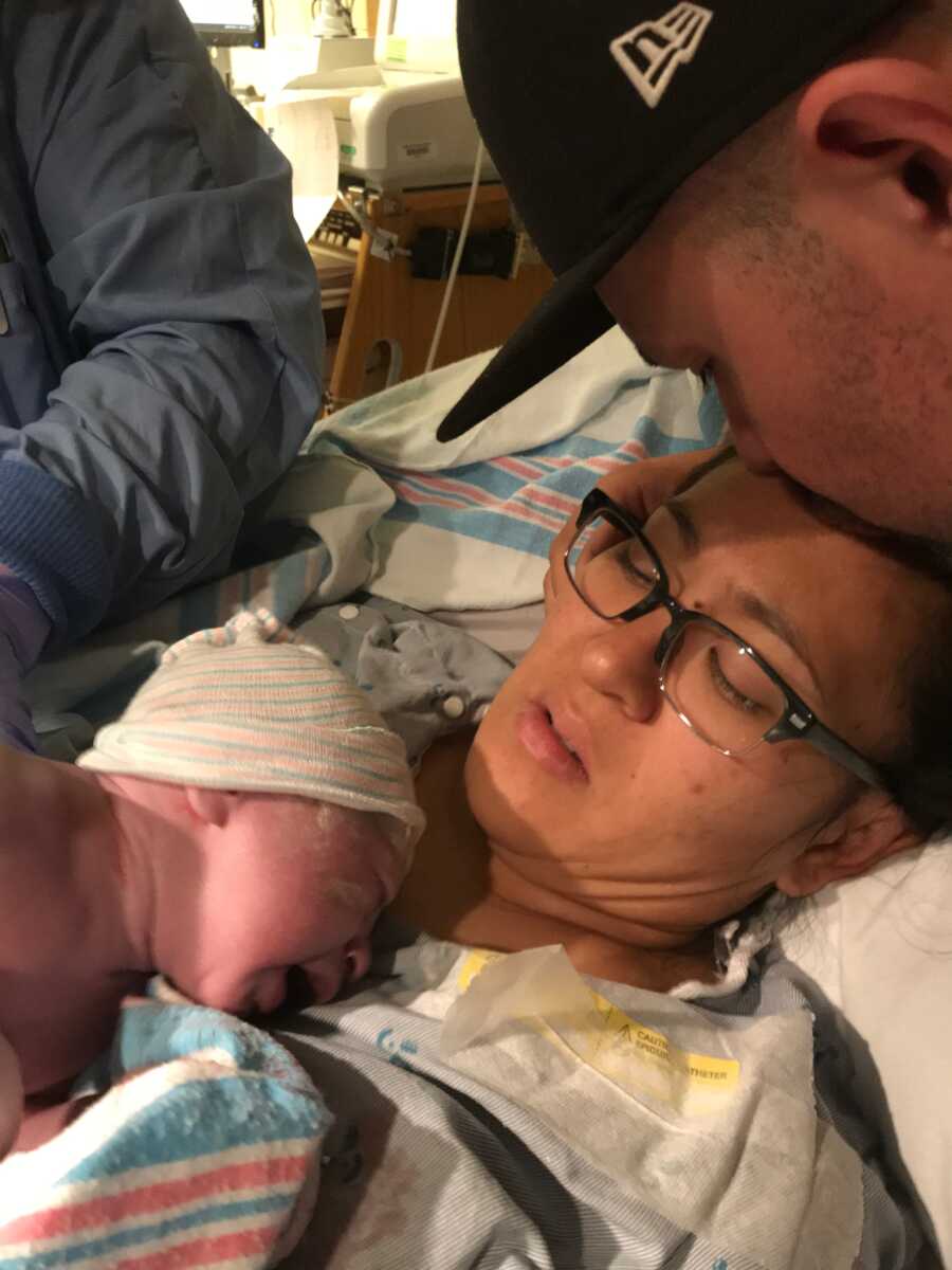 Mom takes picture with baby girl on her chest after labor and delivery.