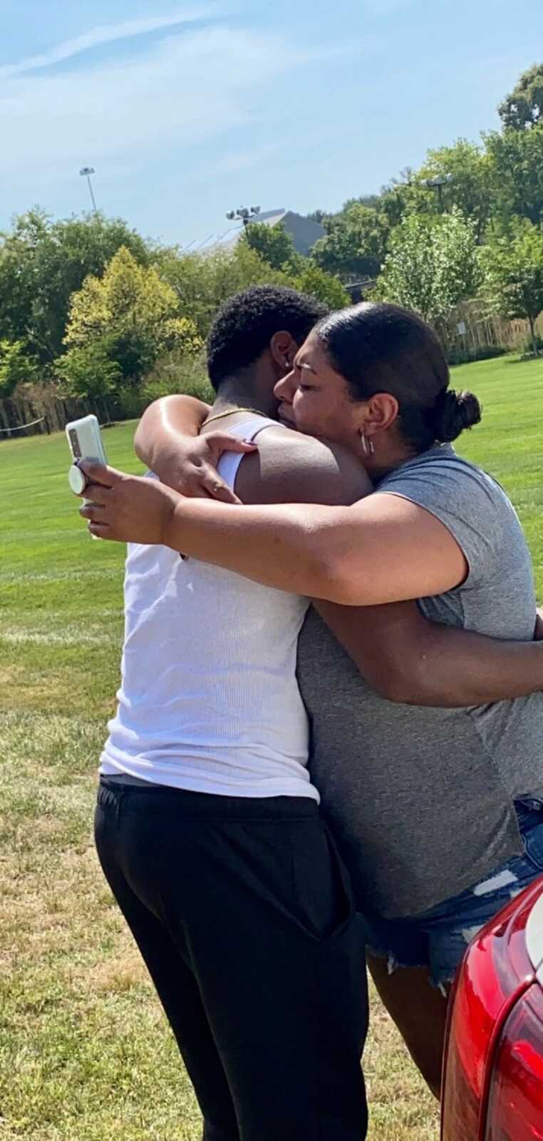 Single mom cries and emotionally hugs firstborn son at graduation.
