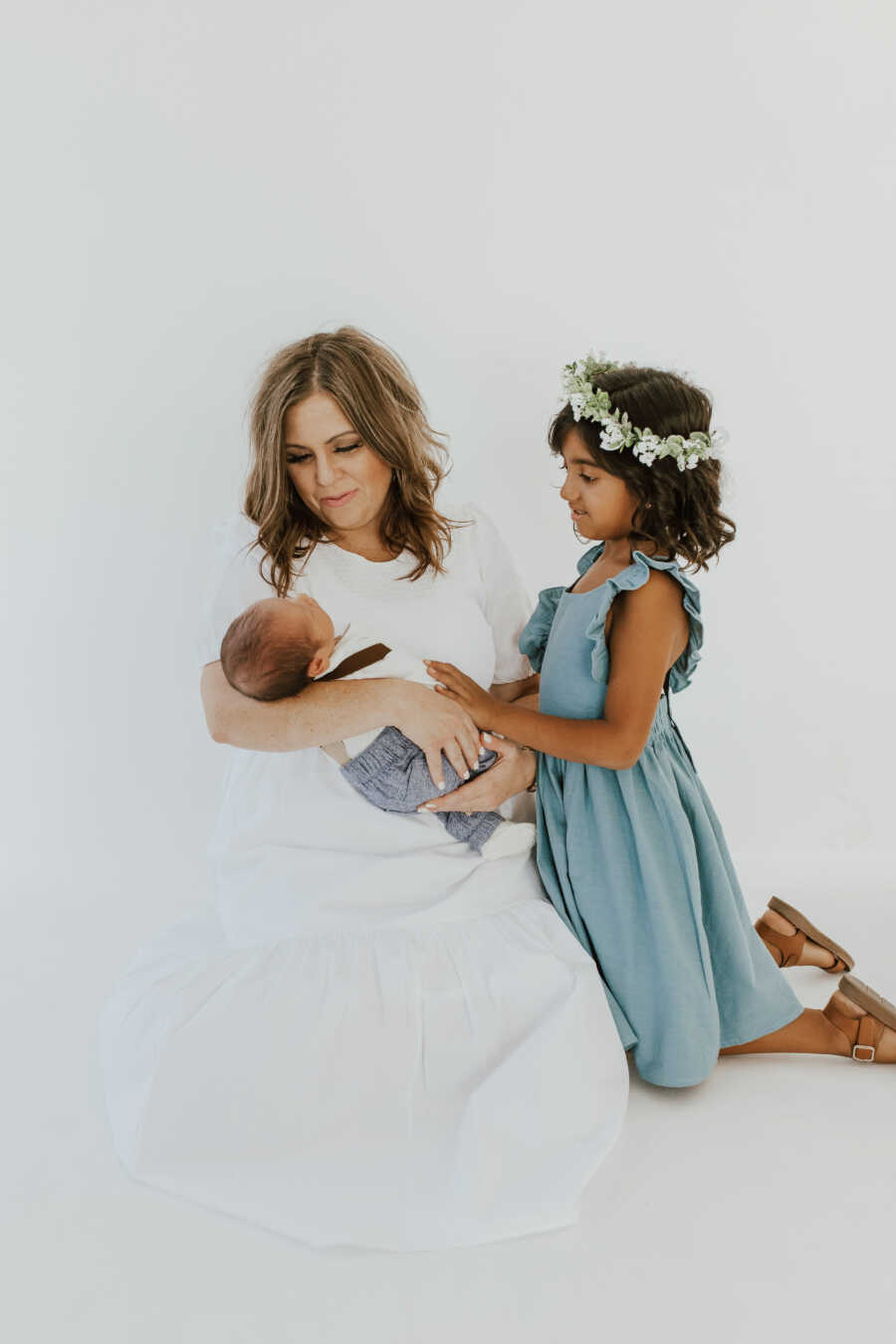 mom holds her adopted son with adopted daughter next to her