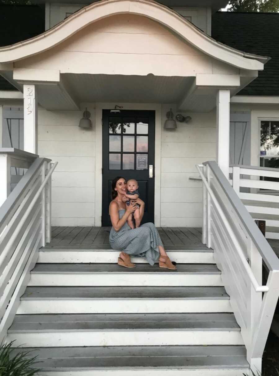 mom holding her son on porch