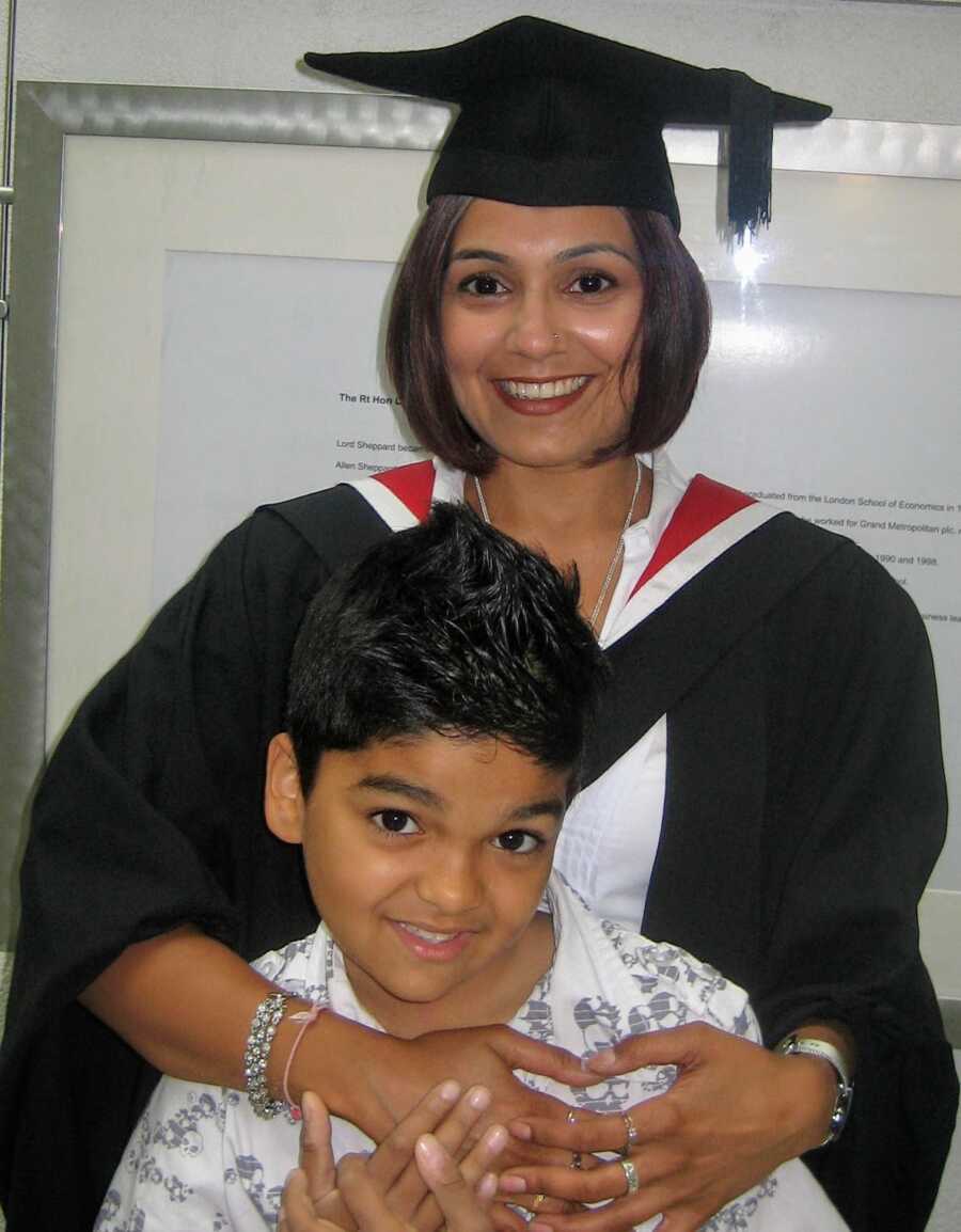 domestic violence survivor in graduation gown and cap with her son smiling