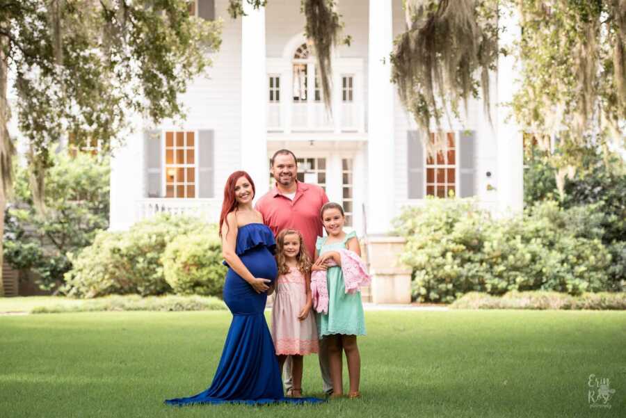 maternity shoot in front of a beautiful house with family