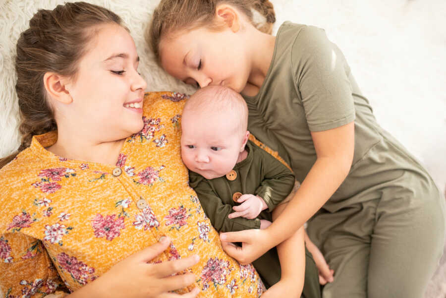 sisters with their rainbow baby brother