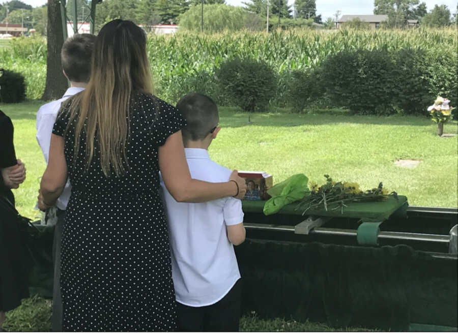 wife and sons at late husband's funeral 