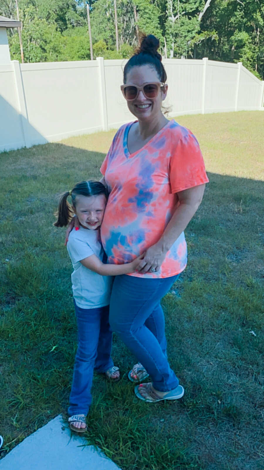 pregnant mom and daughter hugging