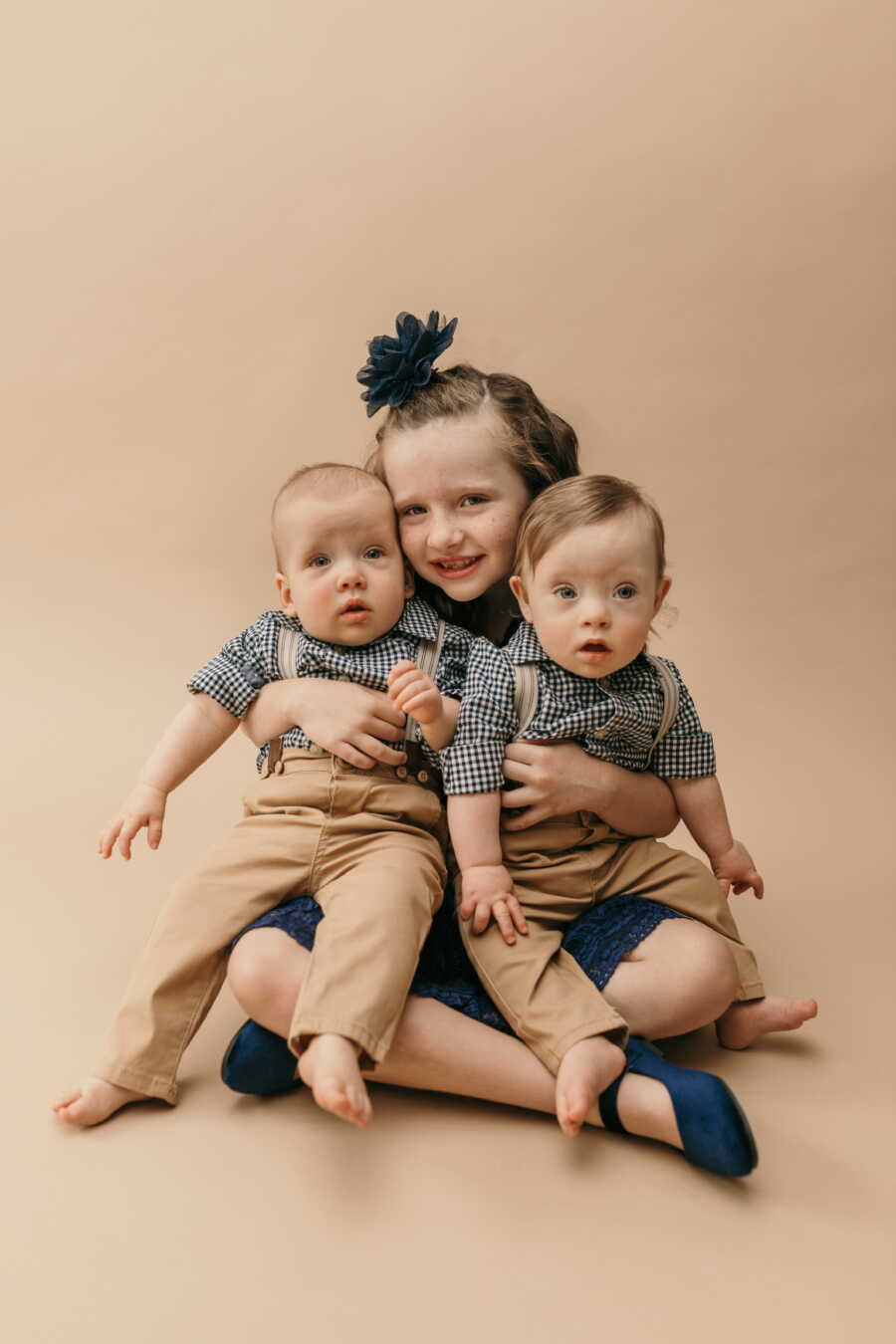 sister with her twin brothers turning one