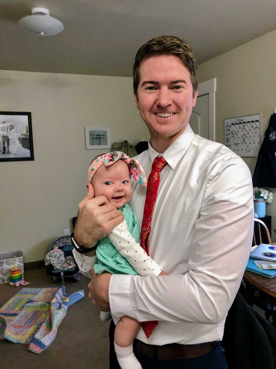 Father smiling and holding his baby daughter