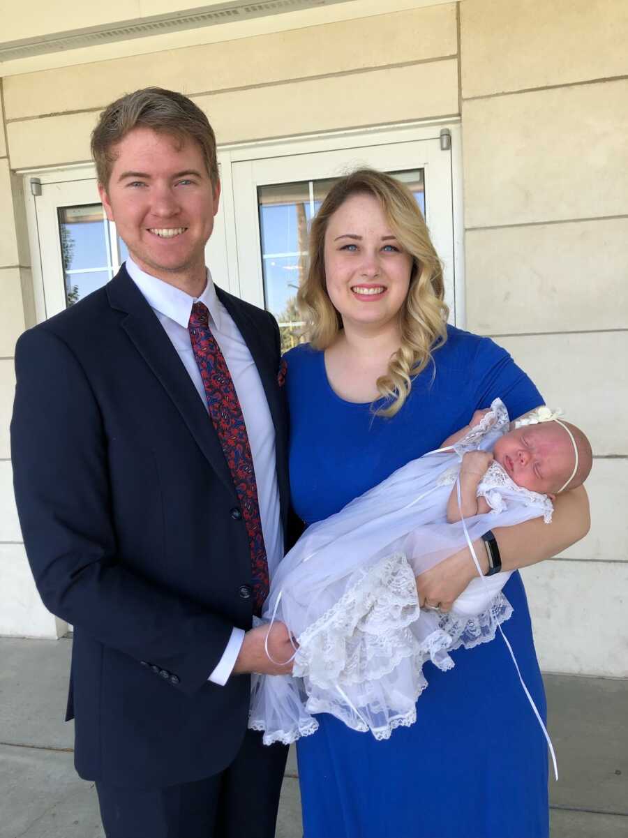 Mother and Father smiling with their baby daughter