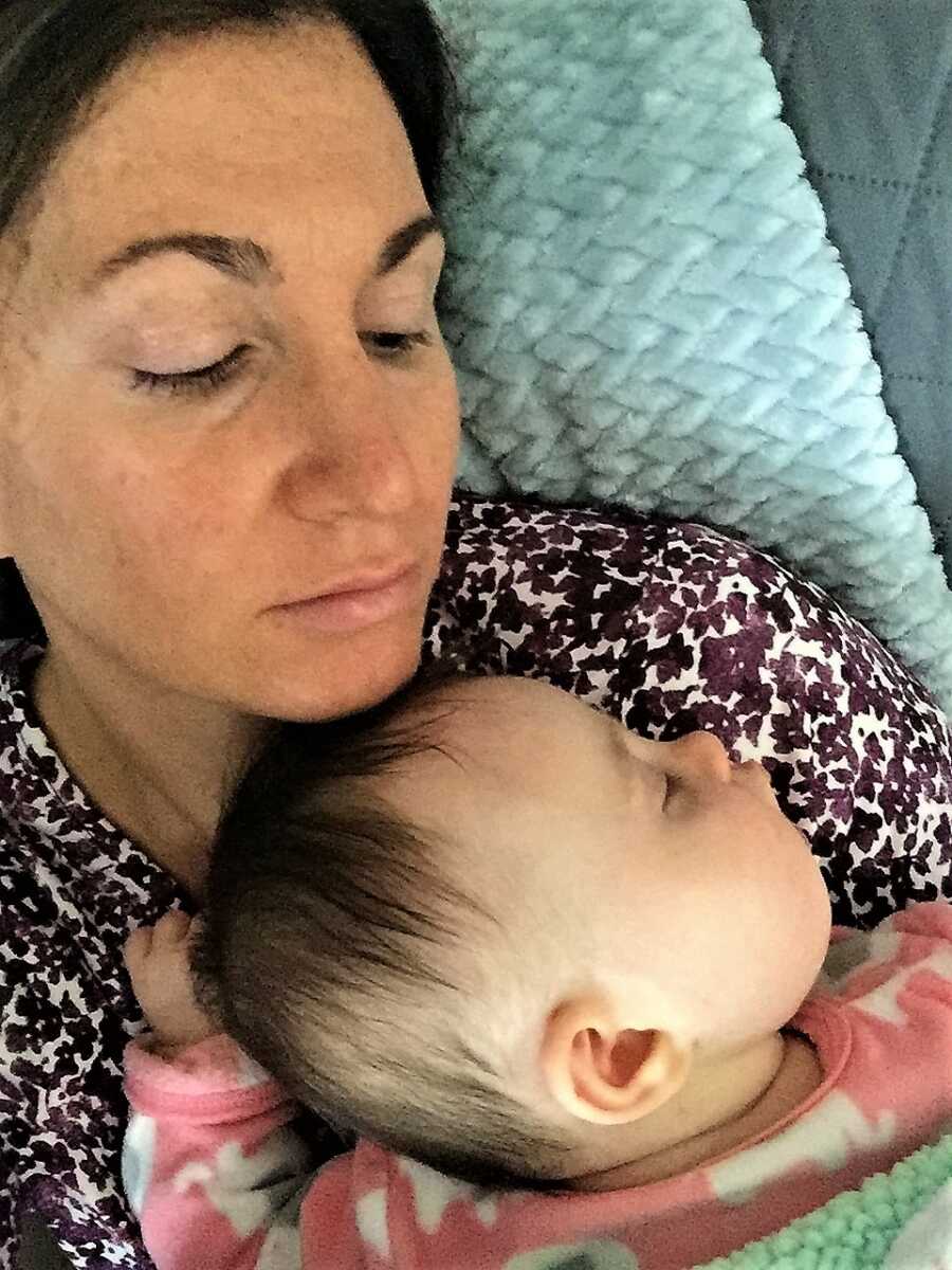 new born girl sleeping on mom's chest