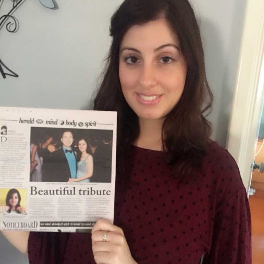 woman holding up newspaper