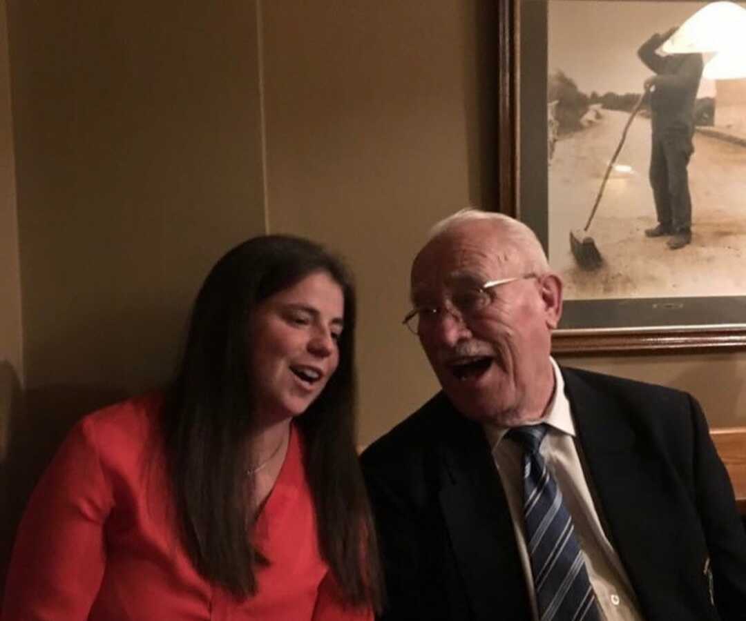 Young woman takes picture laughing with grandpa.