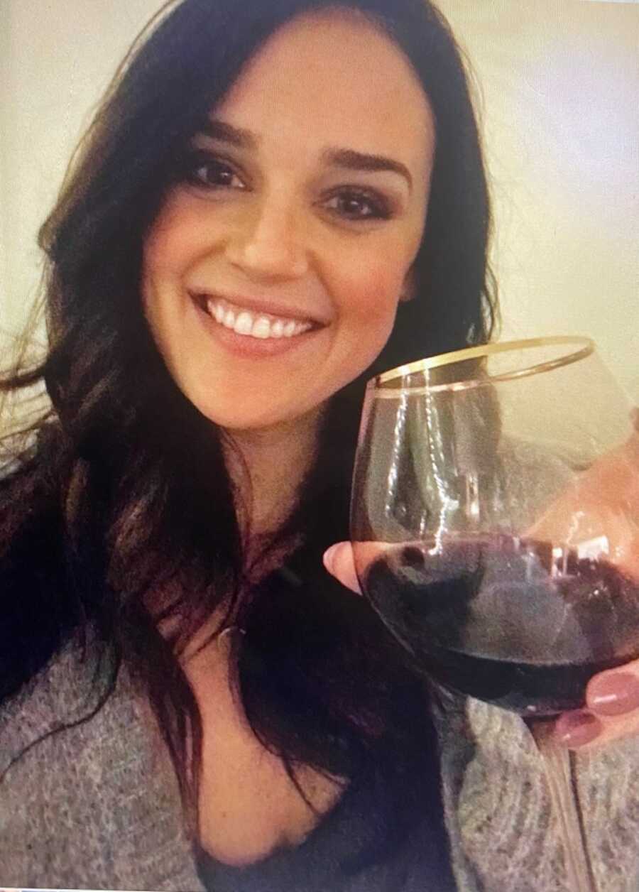 mother holding a wine glass up to the camera