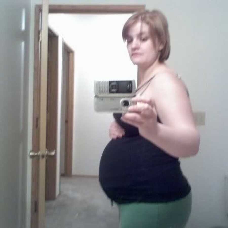 young pregnant woman taking mirror selfie