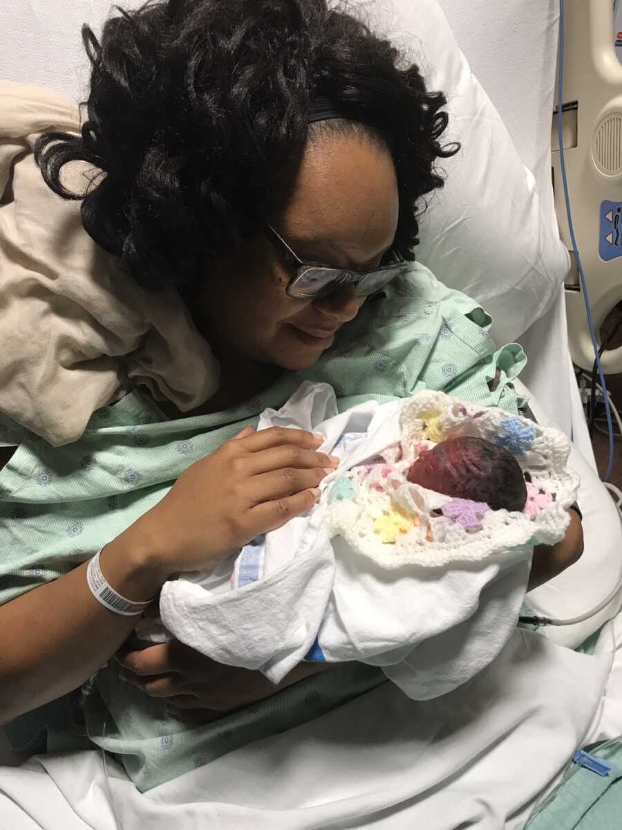 woman holding stillborn baby in hospital bed 
